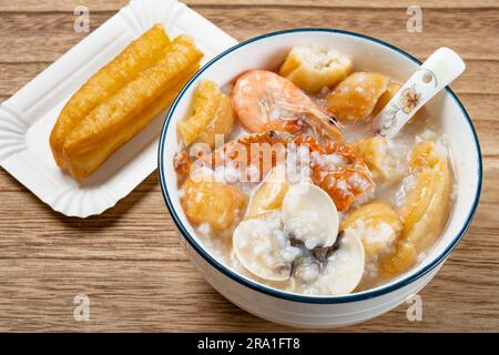 Blick auf Meeresfrüchte-Haferbrei mit Krabben und Garnelen, weißen Muscheln und frittierten Teigstiften in horizontaler Zusammensetzung Stockfoto