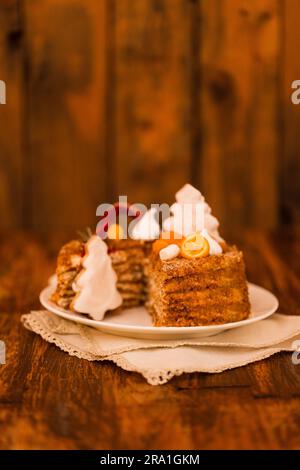 Süßer Weihnachtskuchen mit Lebkuchenmann, Keksen in Form von Weihnachtsbäumen, Marshmallows und Zuckerrohr. Leckerer Neujahrskuchen auf weißem Schweinefleisch Stockfoto