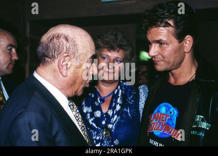 Patrick Swayze, amerikanischer Schauspieler, Sänger und Tänzer, mit Filmproduzent Artur Atze Brauner bei der Eröffnung des Restaurants 'Planet Hollywood' in Berlin, Deutschland 1996. Stockfoto