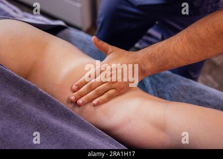 Nahaufnahme eines Masseurs, der eine Fußmassage für die Kundin im Schönheitssalon durchführt. Anti-Cellulite-Massage in der Klinik. Zahlenkorrektur im Stockfoto