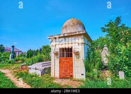 CHERNIVTSI, UKRAINE - 16. JULI 2021: Die alte Grabkrypta inmitten der Dickicht auf dem Friedhof in der Zelena Straße, am 16. Juli in Chernivtsi Stockfoto