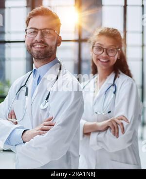 Kollegen Ärzte stehen in der Lobby des Krankenhauses und lächeln in die Kamera Stockfoto