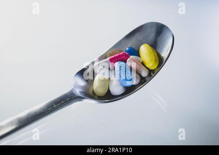 Verschiedene Tabletten und Kapseln in einem Löffel, um das Konzept von Nahrungsergänzungen, Vitaminen, Nahrungsergänzungsmitteln auszudrücken. Stockfoto