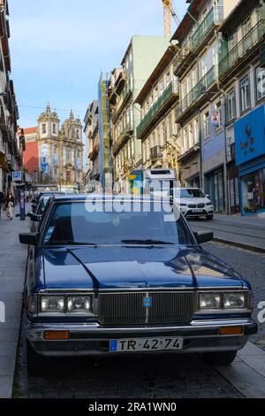 Ein Oldtimer vor der gefliesten Kirche Igreja de Santo Ildefonso in Porto, Portugal, 2023. Stockfoto