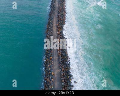 Blick aus der Vogelperspektive auf ein felsiges Wellenbrecher im Port Macquarie in New South Wales, Australien Stockfoto
