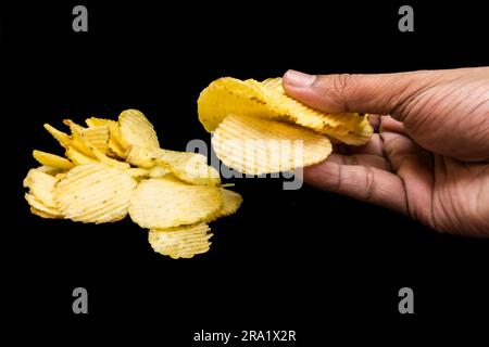 Gesalzene Kartoffelchips, Haufen Waffeln, Haufen Kartoffelchips, Haufen Kartoffelscheiben, gesalzene Kartoffelchips – Wafer, isoliert im schwarzen Hintergrund Stockfoto