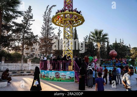 Idlib, Syrien. 29. Juni 2023. Während der Feierlichkeiten des Eid al-Adha-Urlaubs in Idlib reiten die Menschen auf dem Turm im City Park. Eid al-Adha ist das heiligste Fest im Islam, bei dem Muslime Rinder und Schafe schlachten, um der Bereitschaft des Propheten Ibrahim (Abraham) zu gedenken, seinen Sohn Ishmael zu opfern. Kredit: Anas Alkharboutli/dpa/Alamy Live News Stockfoto