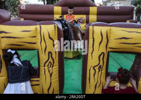 Idlib, Syrien. 29. Juni 2023. Syrische Kinder spielen im Stadtpark während der Feierlichkeiten des Eid al-Adha-Urlaubs in Idlib. Eid al-Adha ist das heiligste Fest im Islam, bei dem Muslime Rinder und Schafe schlachten, um der Bereitschaft des Propheten Ibrahim (Abraham) zu gedenken, seinen Sohn Ishmael zu opfern. Kredit: Anas Alkharboutli/dpa/Alamy Live News Stockfoto