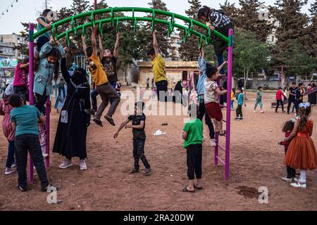 Idlib, Syrien. 29. Juni 2023. Syrische Kinder spielen im Stadtpark während der Feierlichkeiten des Eid al-Adha-Urlaubs in Idlib. Eid al-Adha ist das heiligste Fest im Islam, bei dem Muslime Rinder und Schafe schlachten, um der Bereitschaft des Propheten Ibrahim (Abraham) zu gedenken, seinen Sohn Ishmael zu opfern. Kredit: Anas Alkharboutli/dpa/Alamy Live News Stockfoto