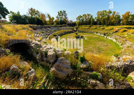 Ruinen des antiken römischen Amphitheaters von 212 v. Chr. im Archäologischen Park von Neapolis in Syrakus, Sizilien, Italien. Stockfoto