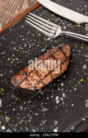Fleischklößchen mit gegrilltem Cheddar auf einem Steinschneidebrett im Steakhouse-Restaurant Stockfoto