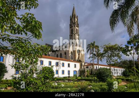 Blick auf Kirche und Gebäude im Sonnenlicht mit grauen Wolken im Hintergrund, Sanctuary Caraca, Minas Gerais, Brasilien Stockfoto