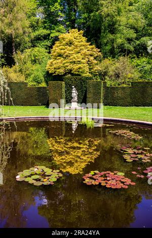 Reflexionen der Statue im stillen Wasser des kreisförmigen Pool Garden am Knightshayes Court, nr Tiverton, Devon, England, Großbritannien Stockfoto