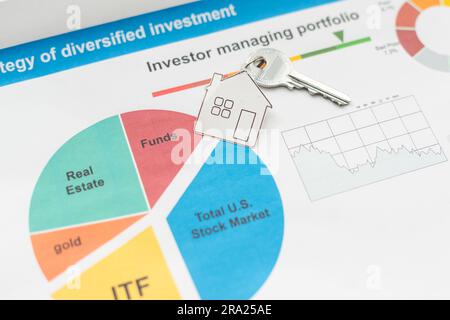 Orangefarbene Dachhäuser und Schlüssel, die auf Diagrammen oder Geschäftsdaten platziert werden. Ideen für Geschäftswachstum, Wirtschaftsdiagramme, Immobilienmärkte, Hypotheken, Haussteuern Stockfoto