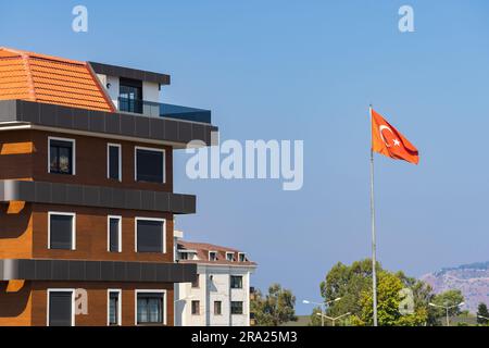 Neu erbautes Apartmentgebäude. Die Flagge der Türkei fliegt in der Nähe des Hauses. Wohnimmobilien. Stockfoto