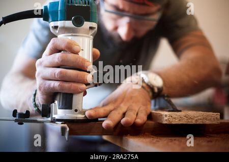 Nahaufnahme der Hand eines Zimmermannes mit einem Holzfräser. Selektiver Fokus. Stockfoto
