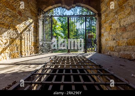 Blick aus einem Gruft-Haus auf dem Elias-Friedhof in Dresden. Unter dem Gitter befindet sich ein ummauerter Grabraum. Die Särge einer Familie wurden hier gestapelt. Diese Form der Bestattung verursachte jedoch, im Gegensatz zu irdenen Gräbern, eine große Geruchsbelästigung. Kryptengebäude mit bogenförmiger Front an der Friedhofswand sind eine Besonderheit des Elias-Friedhofs. Der Elias-Friedhof in Dresden ist seit 1876 stillgelegt und seit 1924 geschlossen Stockfoto