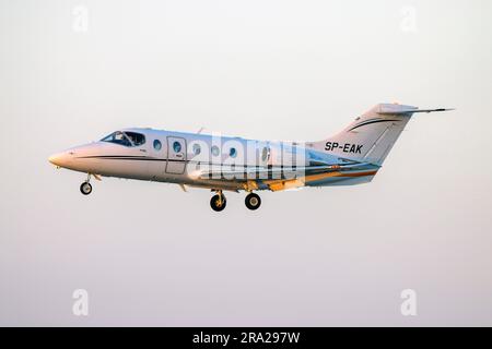 Hawker Beechcraft 400XP (REG: SP-EAK) im Finale, während die Sonne am Horizont untergeht. Stockfoto