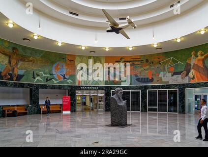 Ein Modell des Pan American Airways System „Yankee Clipper“ ist vom Oberlicht des Marine Air Terminal des Flughafens LaGuardia über dem Wandgemälde „Flight“ aufgehängt. Stockfoto