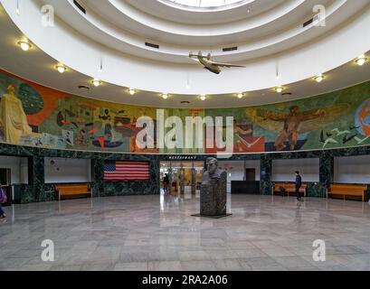 Ein Modell des Pan American Airways System „Yankee Clipper“ ist vom Oberlicht des Marine Air Terminal des Flughafens LaGuardia über dem Wandgemälde „Flight“ aufgehängt. Stockfoto