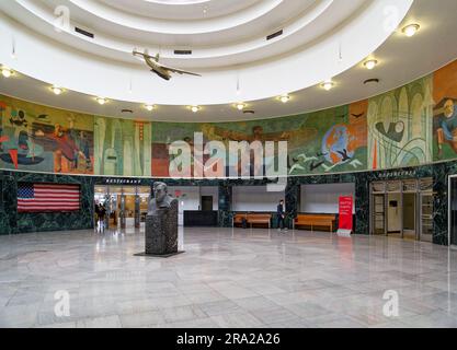 Ein Modell des Pan American Airways System „Yankee Clipper“ ist vom Oberlicht des Marine Air Terminal des Flughafens LaGuardia über dem Wandgemälde „Flight“ aufgehängt. Stockfoto