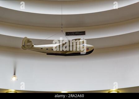 Ein Modell des Pan American Airways System „Yankee Clipper“ ist vom Oberlicht des Marine Air Terminal des Flughafens LaGuardia über dem Wandgemälde „Flight“ aufgehängt. Stockfoto