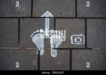 Kaiserslautern, Deutschland. 30. Juni 2023. Das Symbol zeigt den genauen Punkt an, von dem aus ein Bild aufgenommen werden sollte, um eine 3D-Illusion zu erzeugen. Elf internationale Künstler aus 6 Ländern verwandelten den Stiftsplatz (Platz) in dreidimensionale Kunst, wobei das Thema „Digitalisierung und intelligente Stadt“ dieses Jahr stand. 3D Street Art nutzt die Perspektive, um eine optische Illusion des Weltraums zu erzeugen. Die Besucher konnten alle Künstler bei der Arbeit drei Tage lang beobachten. Dies ist der dritte und letzte Tag der Veranstaltung. Kredit: Gustav Zygmund/Alamy News Stockfoto