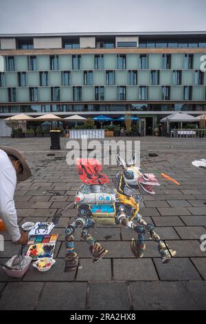Kaiserslautern, Deutschland. 30. Juni 2023. Fast fertig – Limnesh Augustine beendet sein farbenfrohes Gemälde. Elf internationale Künstler aus 6 Ländern verwandelten den Stiftsplatz (Platz) in dreidimensionale Kunst, wobei das Thema „Digitalisierung und intelligente Stadt“ dieses Jahr stand. 3D Street Art nutzt die Perspektive, um eine optische Illusion des Weltraums zu erzeugen. Die Besucher konnten alle Künstler bei der Arbeit drei Tage lang beobachten. Dies ist der dritte und letzte Tag der Veranstaltung. Kredit: Gustav Zygmund/Alamy News Stockfoto