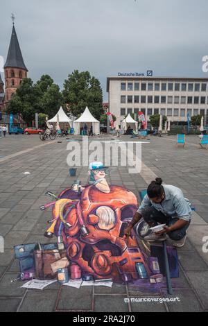 Kaiserslautern, Deutschland. 30. Juni 2023. Der mexikanische Künstler Mauricio Vargas vollendet sein Gemälde aus dem Jahr 3D. Elf internationale Künstler aus 6 Ländern verwandelten den Stiftsplatz (Platz) in dreidimensionale Kunst, wobei das Thema „Digitalisierung und intelligente Stadt“ dieses Jahr stand. 3D Street Art nutzt die Perspektive, um eine optische Illusion des Weltraums zu erzeugen. Die Besucher konnten alle Künstler bei der Arbeit drei Tage lang beobachten. Dies ist der dritte und letzte Tag der Veranstaltung. Kredit: Gustav Zygmund/Alamy News Stockfoto