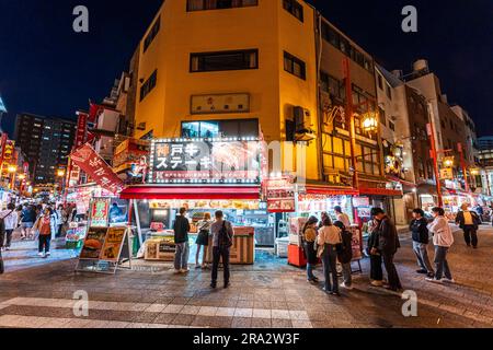 Nachtsicht auf einen beliebten beleuchteten Kobe Beef Take Away Stand an der Ecke Nankinmachi Square in Chinatown, Kobe. Stockfoto