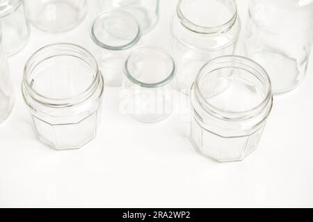 Verschiedene Glasbehälter ohne Deckel auf weißem Hintergrund, Recycling. Konzept der zweiten Lebensdauer von Werkstoffen, verschiedene Anwendungsmöglichkeiten für Glasfläschchen. Verstanden Stockfoto