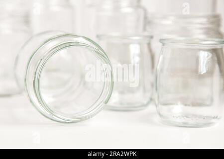 Verschiedene Glasbehälter ohne Deckel auf weißem Hintergrund, Recycling. Konzept der zweiten Lebensdauer von Werkstoffen, verschiedene Anwendungsmöglichkeiten für Glasfläschchen. Stockfoto