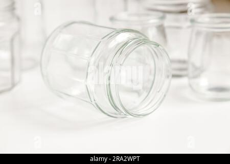 Verschiedene Glasbehälter ohne Deckel auf weißem Hintergrund, Recycling. Konzept der zweiten Lebensdauer von Werkstoffen, verschiedene Anwendungsmöglichkeiten für Glasfläschchen. Stockfoto