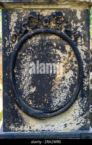 Eine Schlange, die ihren eigenen Schwanz umrahmt, als Symbol für die Unendlichkeit, ein ovaler eingeprägter Medaillon, gekrönt von einem geschnitzten steinernen Bogen auf einem Grabstein auf dem Elias-Friedhof in Dresden, Sachsen, Deutschland. Der 1680 als Pesthaus angelegte Elias-Friedhof wurde 1724 unter den Baumeistern George Bähr, Architekt der Dresdner Frauenkirche, und Johann Gottfried Fehre, der 41 gewölbte Grufthäuser mit gewölbten Fronten entlang der West- und Nordmauern hinzufügte, erheblich erweitert und ummauert – eine architektonische Innovation für Dresden zu dieser Zeit. Die letzte Beerdigung fand am 21. Juni 1876 statt, und th Stockfoto