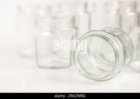 Verschiedene Glasbehälter ohne Deckel auf weißem Hintergrund, Recycling. Konzept der zweiten Lebensdauer von Werkstoffen, verschiedene Anwendungsmöglichkeiten für Glasfläschchen. Stockfoto