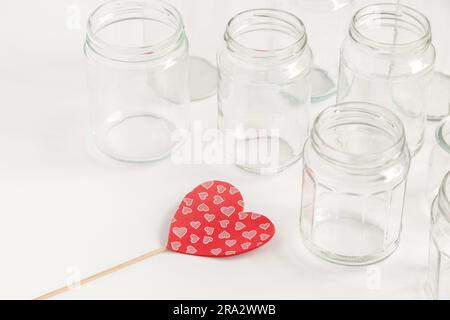 Verschiedene Glasbehälter ohne Deckel auf weißem Hintergrund, Recycling. Konzept der zweiten Lebensdauer von Werkstoffen, verschiedene Anwendungsmöglichkeiten für Glasfläschchen. Stockfoto