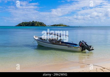 Nacula; Fidschi: 25. Juni; 2023: Boot am atemberaubenden idyllischen blauen Lagunenstrand auf der Insel Yasawa auf Fidschi im Südpazifik Stockfoto