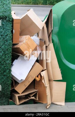 Ein Stapel Pappe wird für Recycling sortiert. Pappe und Altpapier werden gesammelt und zum Recycling in der Stadt verpackt. Vertikale Ansicht. Stockfoto