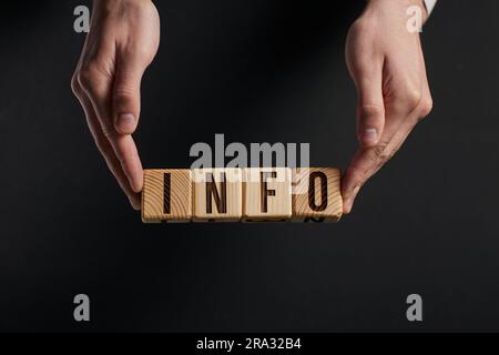 Mit der Hand werden die Wörter INFO durch eine Lupe auf einem Bla untersucht Stockfoto