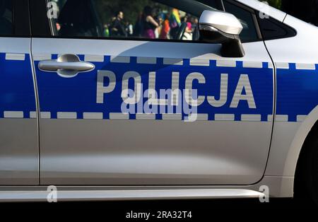 Schild an der Seitentür des Polizeiwagens in Polen. Briefe in polnischer Sprache, Policja bedeutet Polizei. Polnische Offiziere, Streifenwagen. Stockfoto