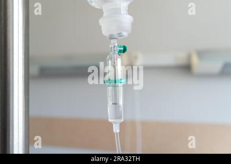 Infusionsbeutel mit Tropfzähler auf einem Infusionsständer oder Flaschenhalter. Intravenöse Therapie, Hängebeutel mit Medikamenten für einen Patienten in einem Krankenhauszimmer. Stockfoto