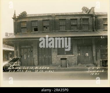 Foto von der Außenseite von Los 12, Bl. 2258, 213 Mkt. Ave (Seite A St), D.P. 126. Zeigt Außenfassaden des Marktgebäudes mit Schildern für F. Singer, Fancy Bananas und Celery. Stockfoto