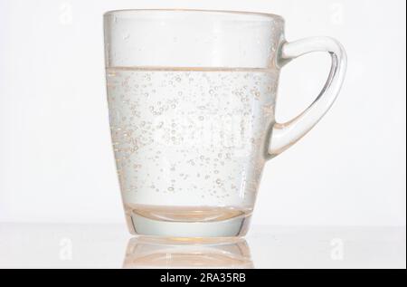 Ein Glas Mineralwasser vor weißem Hintergrund. Stockfoto