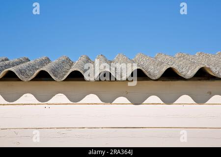 Altes gefährliches Dach aus Wellasbestpaneelen - eines der gefährlichsten Materialien in Gebäuden und Bauindustrie, sogenannter Hidd Stockfoto