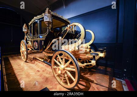 Royal Coach, Carriage, der Diamond Jubilee State Coach, der während der Krönungsprozession von König Karl III. Verwendet wurde, ist in den Royal Mews Stables ausgestellt. Stockfoto