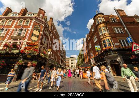 Überfüllte Stadtstraße mit Touristen auf dem Covent Garden Market in der Londoner City mit beliebten Geschäften, Restaurants und Kneipen. Eine Top-Attraktion in Großbritannien. Stockfoto