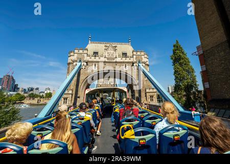 Touristenbus auf der Tower Bridge in London. Der Doppeldeckerbus mit offenem Oberdeck ist die beste Möglichkeit, Londons Wahrzeichen zu sehen, die Skyline und das Stadtbild zu genießen. Stockfoto