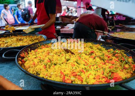 Paella, ein klassisches spanisches Reisgericht, wird zum Mitnehmen zubereitet. Internationale Speisen und Küche finden Sie auf allen Londoner Straßenmärkten. Stockfoto