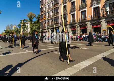 Parade der Heiligen Woche, Semana Santa Prozession in Madrid, Spanien. Frauen in traditioneller spanischer Trauerkleidung, die mit Palmenblättern an der Kathedrale spazieren gehen. Stockfoto