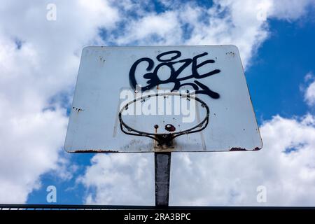 Basketballkorb gegen bewölkten Himmel in urbaner Umgebung. Stockfoto